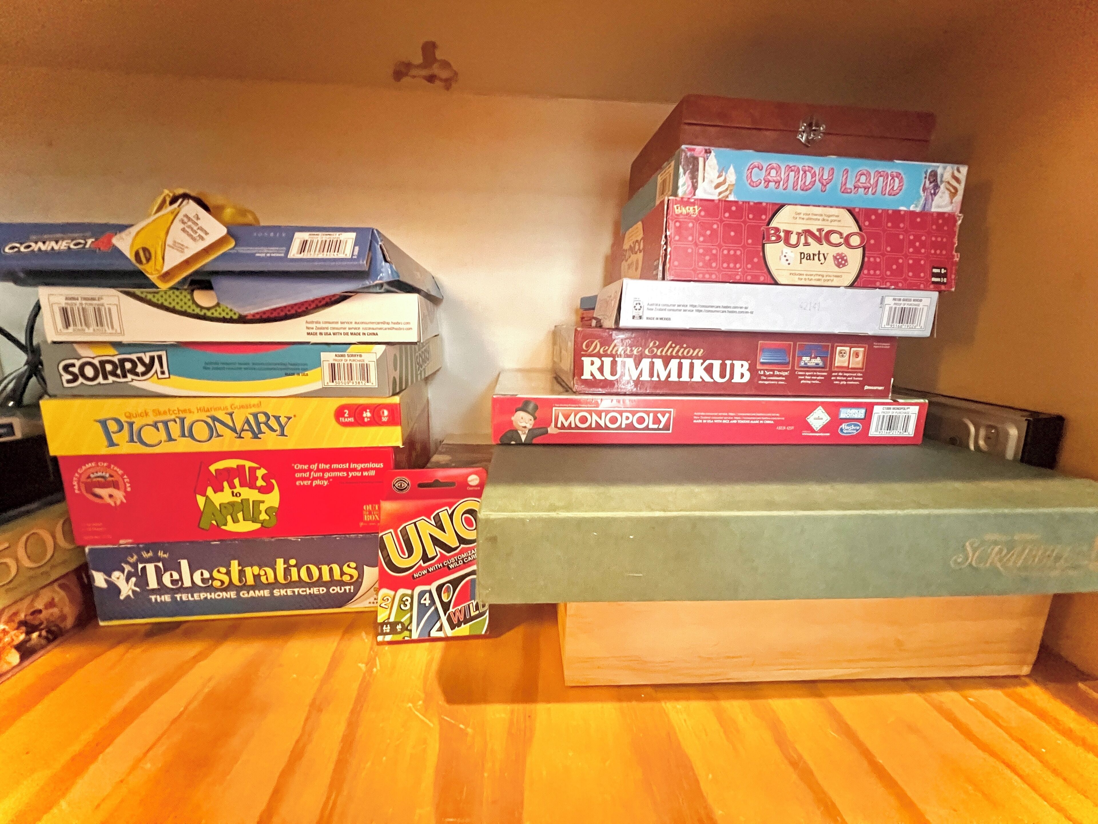 A stack of board games on a shelf.