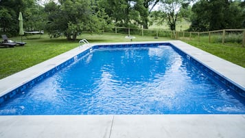 Una piscina al aire libre, una piscina climatizada