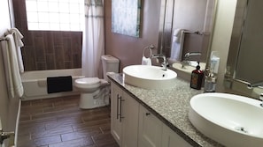 Une salle de bain avec des toilettes, un lavabo et une baignoire.