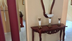 A wooden console table with three decorative vases and a mirror. - Nicole's Guest Home (Higuey)