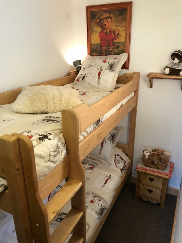 A bunk bed with patterned bedding, a small bedside table with a basket, and a teddy bear on a shelf. - CHIC & COZY. 100m FROM THE SLOPES. 360° VIEWS. VERY QUIET HALF CHALET IN MEGEVE (Megève)