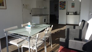 A compact living space with a dining area, kitchenette, and a small seating area. - ATTIC + PRIVATE TERRACE AND FREE WIFI (Sevilla)