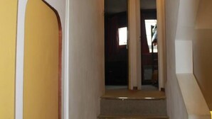 A staircase leading to a landing with a door on the left. - Residential flat (Morzine)