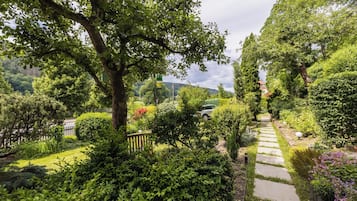 Ein Gartenweg, umgeben von üppigem Grün und Bäumen.