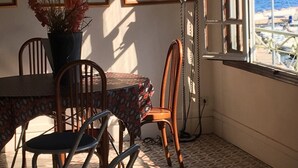 A dining area with a table, chairs, and framed pictures on the wall. - Nice apartment in a character villa next to the sea in Banyuls (Banyuls-Sur-Mer)