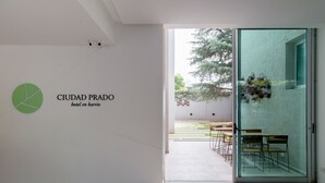 An interior space with a sign reading "CIUDAD PRADO hotel en barrio". - Ciudad Prado Hotel (Córdoba)