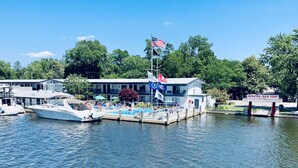Ein an einem Steg festgemachtes Boot, ein Gebäude mit einer Flagge und ein Fahnenmast mit einer US-amerikanischen Flagge.