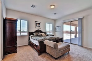 Relax in this serene bedroom with a large bed, a wardrobe, and a comfortable armchair.