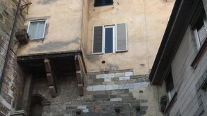 Une arche en pierre surmontant une porte d’entrée dans une ville historique, avec un commerce appelé « Amorini Dolci & Caffe » situé en dessous.