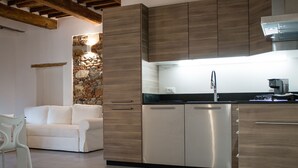 Une cuisine moderne dotée d’appareils électroménagers en acier inoxydable, de meubles en bois et d’un mur décoratif en pierre.
