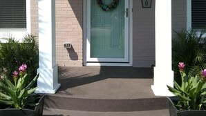 A house with a front porch, a door with a wreath, and a mailbox. - Truly Unique! 1938 Historic Beach House (Carolina Beach)