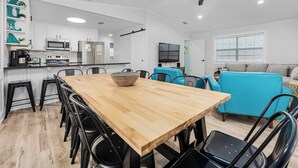 A modern kitchen with white cabinets, a wooden dining table, and black chairs. - 1min Walk To The Beach, Private Heated Pool, Pet Friendly, Zula Dreams Destin (Destin)