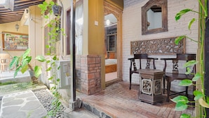 Une pièce de style traditionnel avec une cheminée en briques, des meubles en bois et un chemin de pierre menant à une porte.