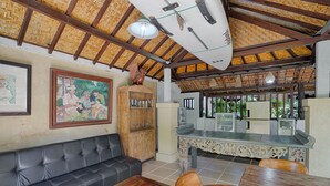 Un coin repas avec une table et des chaises en bois, un canapé en cuir noir et un meuble décoratif.
