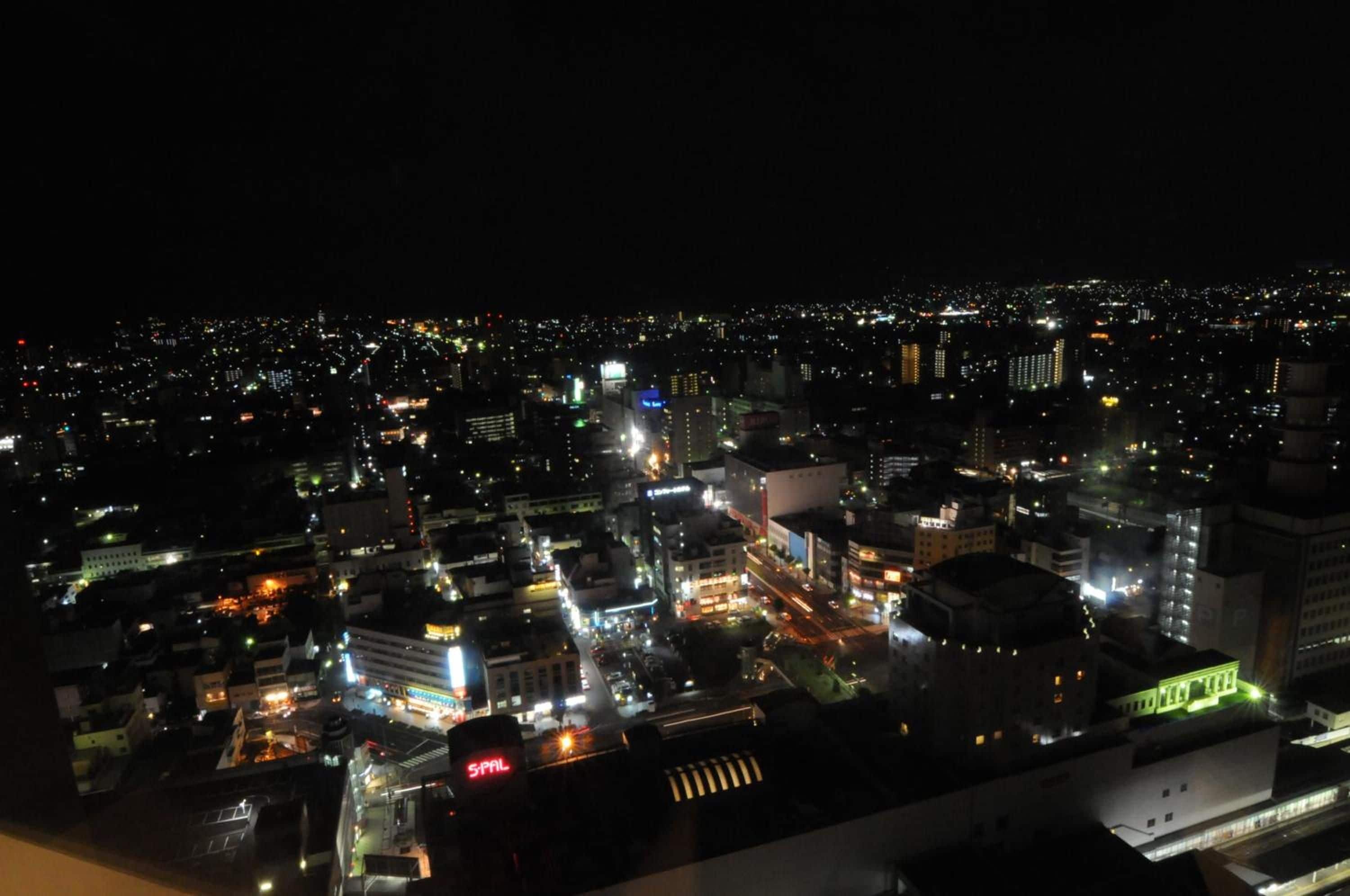 A nighttime cityscape with illuminated buildings and streets.
