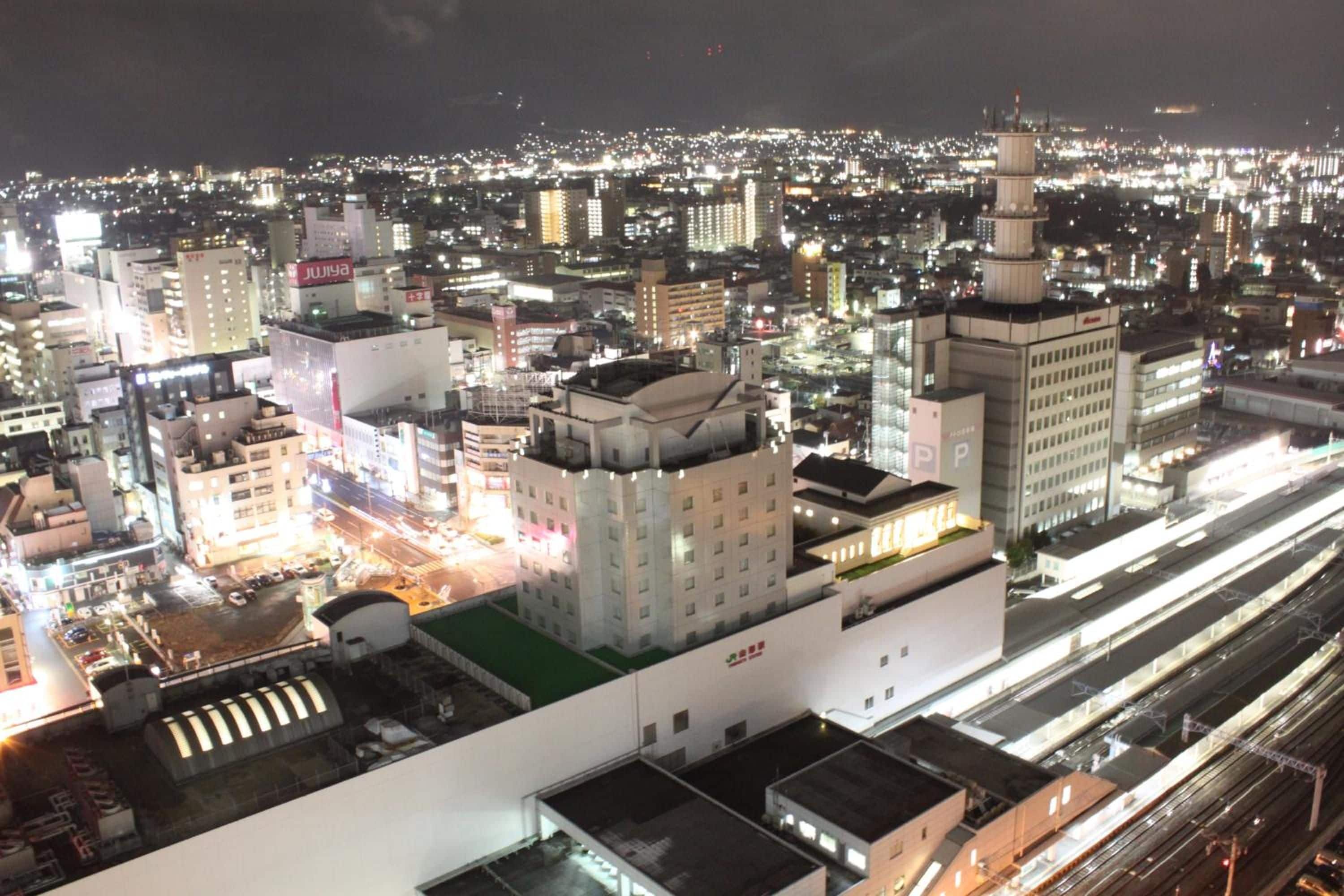 A cityscape at night with illuminated buildings and a prominent tower.