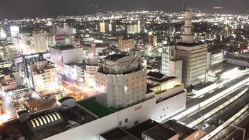 A cityscape at night with illuminated buildings and a prominent tower.