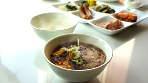 A table with various dishes including a bowl of soup, a plate of sausages, and other food items. - Yamagata Eki Nishiguchi Washington Hotel (Yamagata)