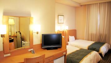 A hotel room with a desk, a television, two beds, a mirror, and a window with curtains.