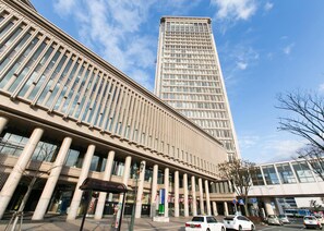 A modern building with a prominent vertical structure and a series of columns. - Yamagata Eki Nishiguchi Washington Hotel (Yamagata)