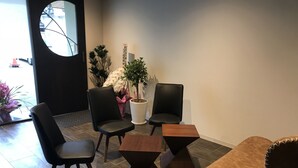 Un interior moderno con sillas de cuero negro, una mesa de madera y plantas en macetas.