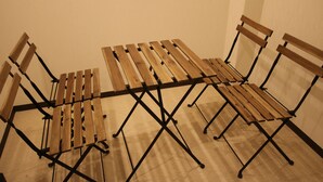 Una mesa de comedor con cuatro sillas de madera y estructura metálica.