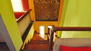 A staircase with wooden railings and a mural on the wall. - D'Java Homestay Unit Ambarrukmo 2 By The Grand Java (Depok)