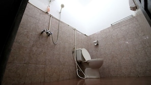A bathroom with a toilet, a shower, and a hand dryer.
