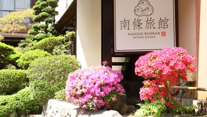 Un edificio japonés tradicional con un cartel que muestra el nombre 'Nanjyo Ryokan'.