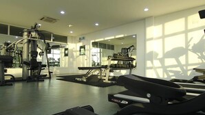 A gym with exercise equipment, mirrors, and a weight rack. - Sabah Luxury Cozy Family Suite (Kota Kinabalu)