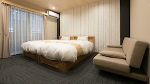 A bedroom with a large bed, a sofa, and a window with curtains. - Stay SAKURA Kyoto Ryu (Kyoto)
