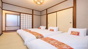 Ein traditionell japanisch gestaltetes Hotelzimmer mit Tatami-Böden, Shoji-Schirmen und einem großen Fenster.