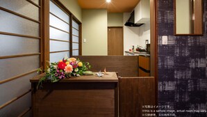 A room with a wooden reception desk, a mirror, and a view of a kitchen. - Stay SAKURA Kyoto To-ji Machiya (Kyoto)