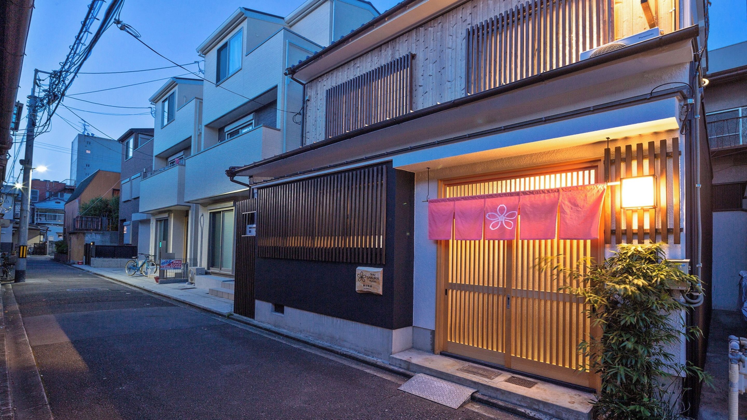 A traditional Japanese building with a wooden gate and a sign indicating a restaurant.