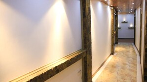 Um corredor com detalhes em pedra nas paredes e piso em azulejos.