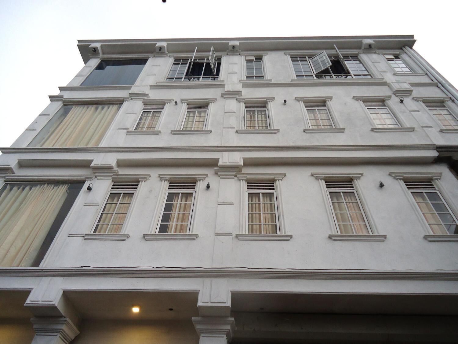 A multi-story building with a symmetrical facade, large windows, and a central entrance.