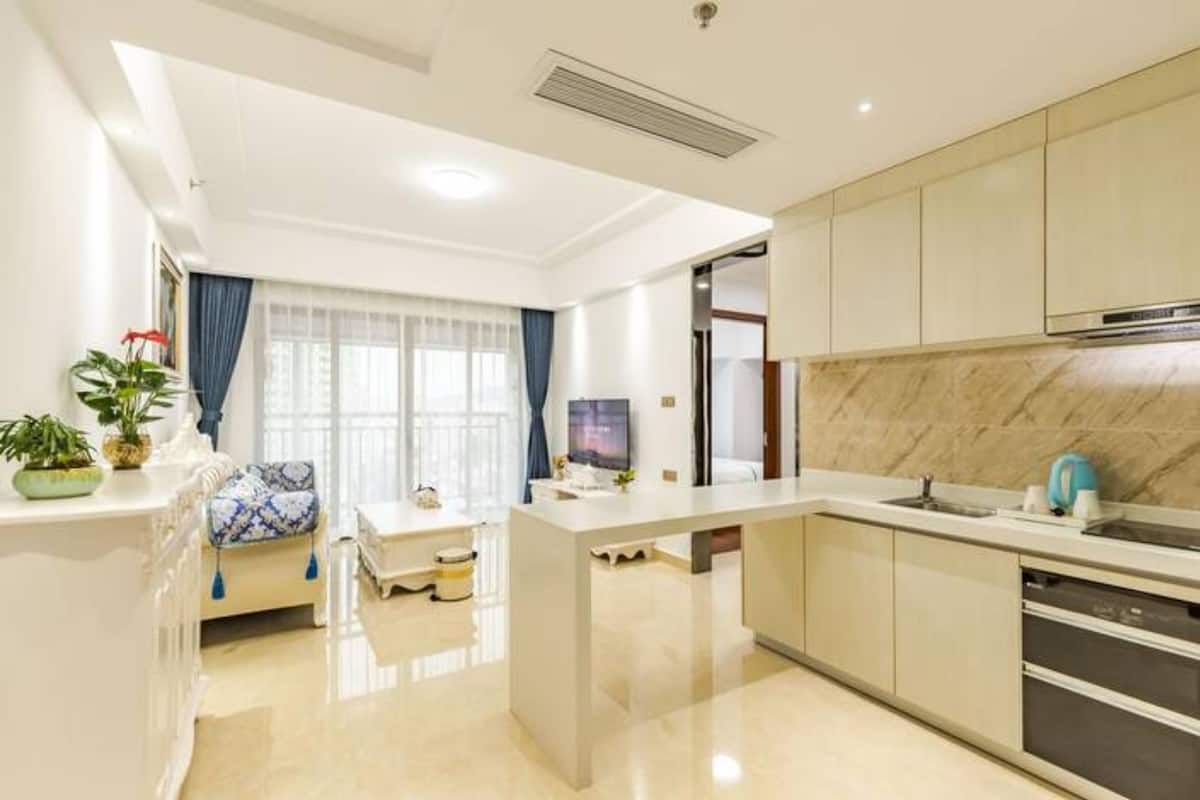 A modern kitchen with a central island, built-in cabinets, and a stainless steel range hood.