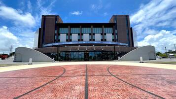A modern building with a curved entrance and a brick pathway leading to it.