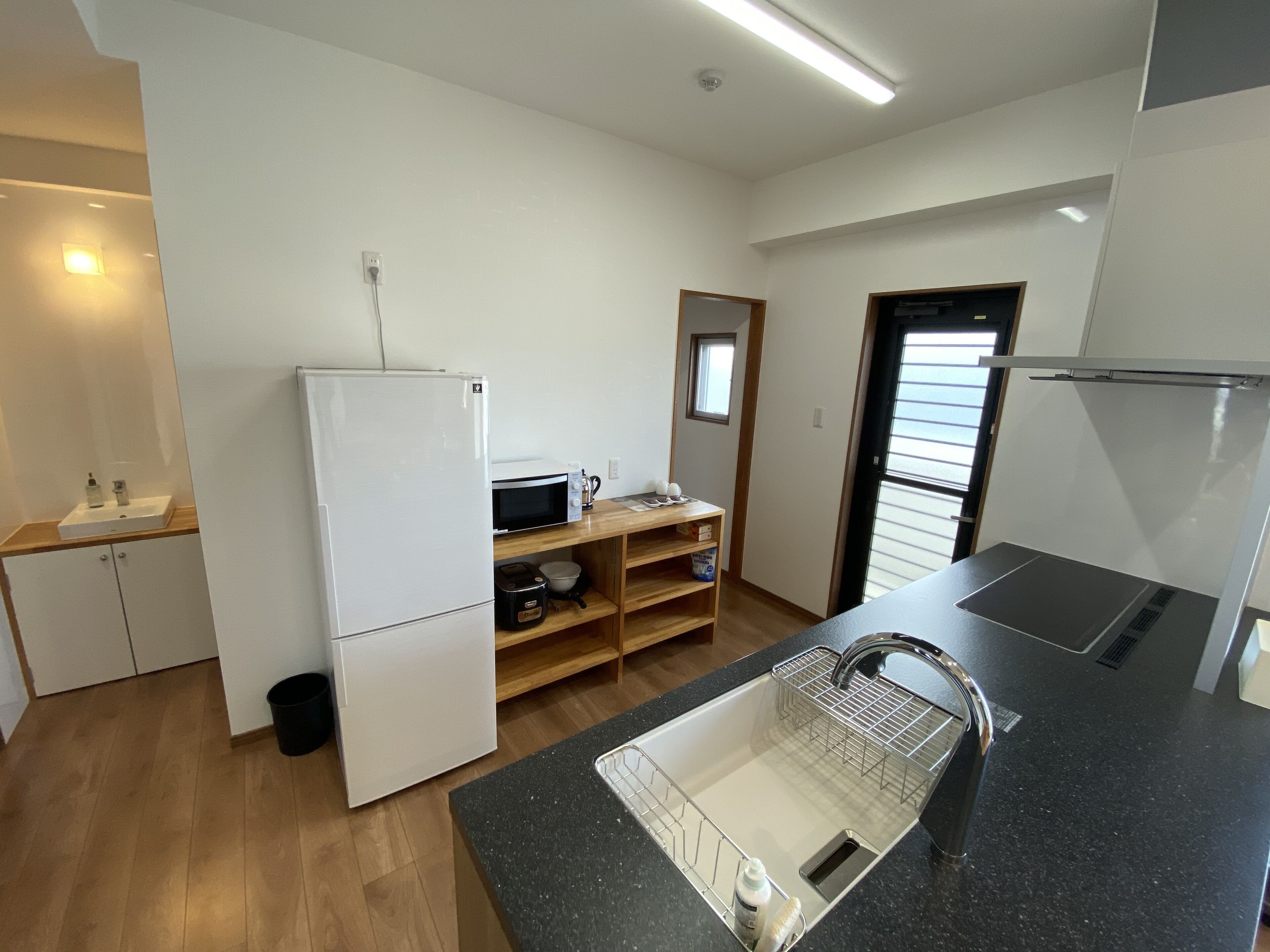 A compact kitchen with a refrigerator, microwave, and sink.