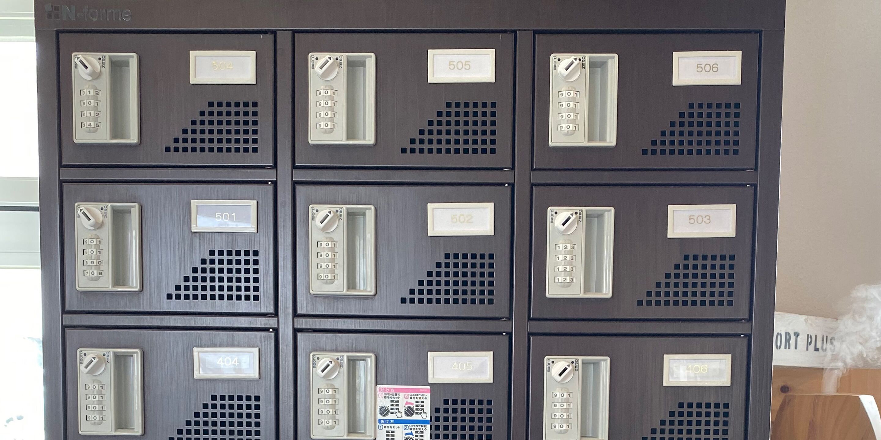 A row of metal mailboxes with numbers 501 to 506, each with a keyhole and a label.