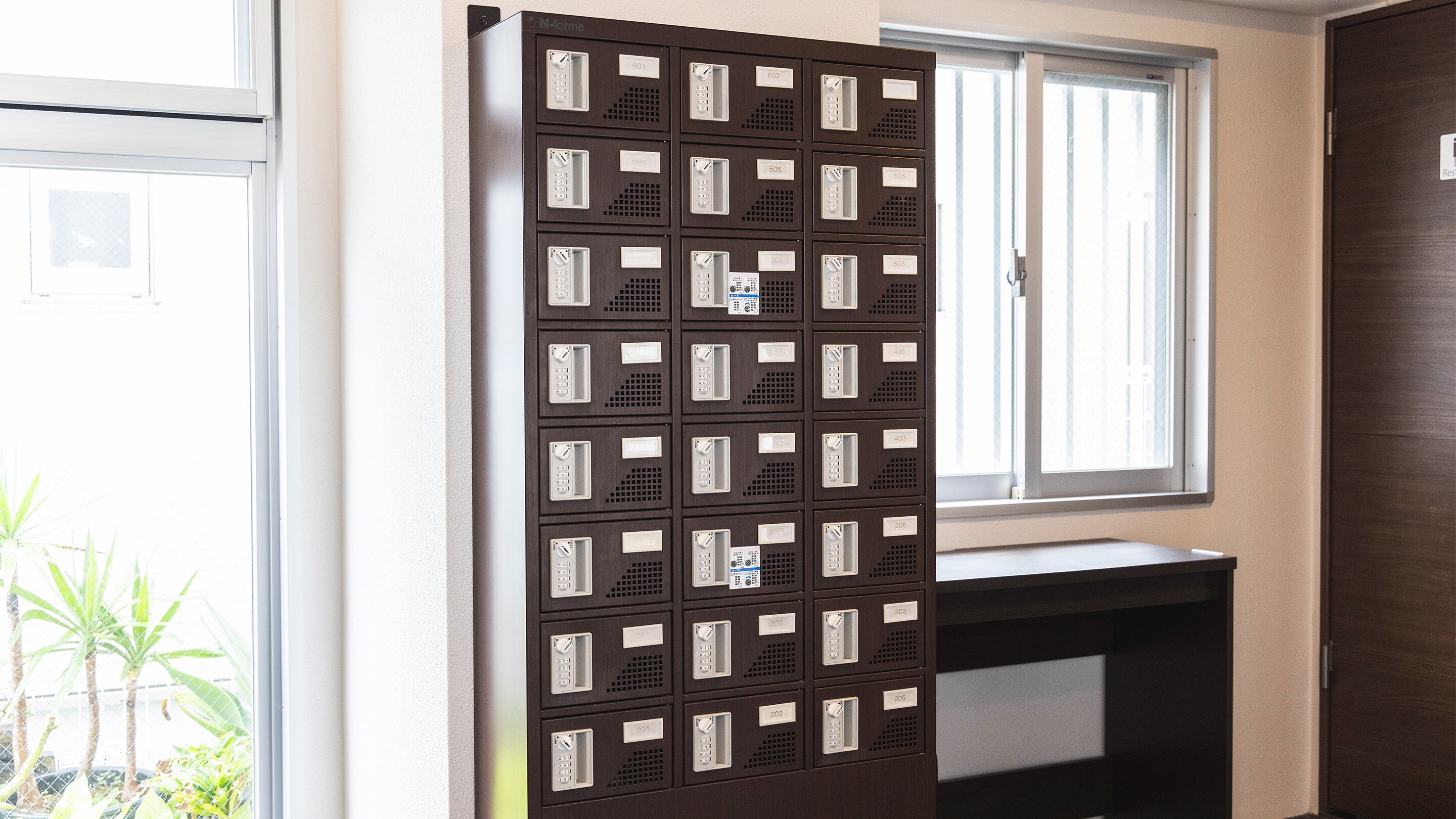 A row of mailboxes with numbers on them, a window, and a door.