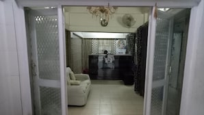A room with a sliding glass door leading to a living area with a sofa and a small table. - Hotel Kameng (Papumpare)
