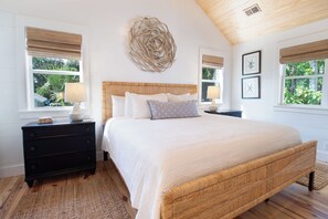 Une chambre à coucher avec un grand lit, deux tables de chevet, un élément décoratif fixé au mur et des tableaux encadrés.