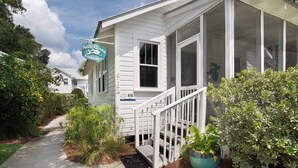 A white house with a porch, a sign reading "Sea Glass Cottage," and a number "616" on the door. - One house plus 2 cottages on the same lot~Family Houses (Folly Beach)