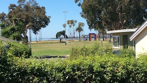 A view of a park with a building, trees, and a clear sky.