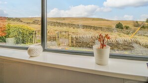 A window with a view of a stone wall and a grassy field. - 1 Braeside (Bishop Auckland)