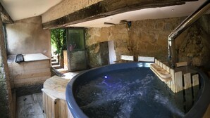 A hot tub in a rustic room with stone walls and wooden beams. - La Cannara (Marta)