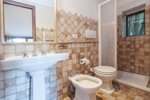 A bathroom with a sink, bidet, toilet, and a shower area. - La Cannara (Marta)