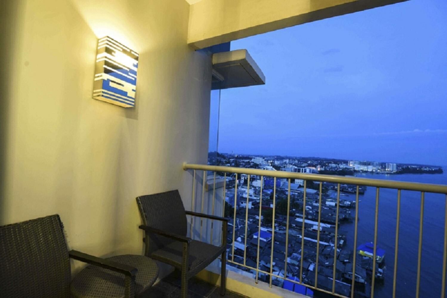 A balcony with a view of a cityscape and water.