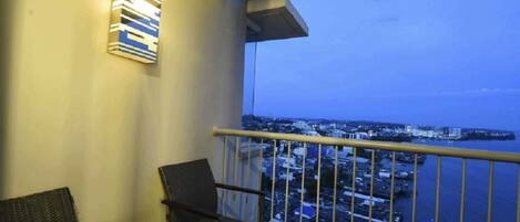 A balcony with a view of a cityscape and water.